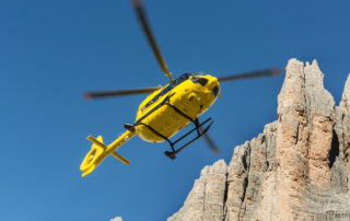 Yellow helicopter flying under blue sky