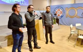 Slovenian Mountain Rescue Association (GRZS), Johannes Kreuzer (cosinuss°, left) handing over the sensors to Dr. Gregor Dolinar (GRZS, right) and Luka Camlek (GRZS, middle).